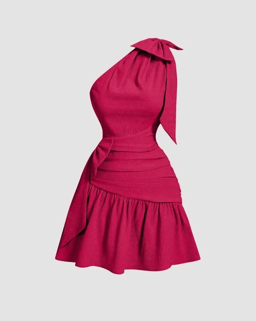 Front view of Hot pink mini dress featuring an asymmetrical neck and a prominent bow at the front