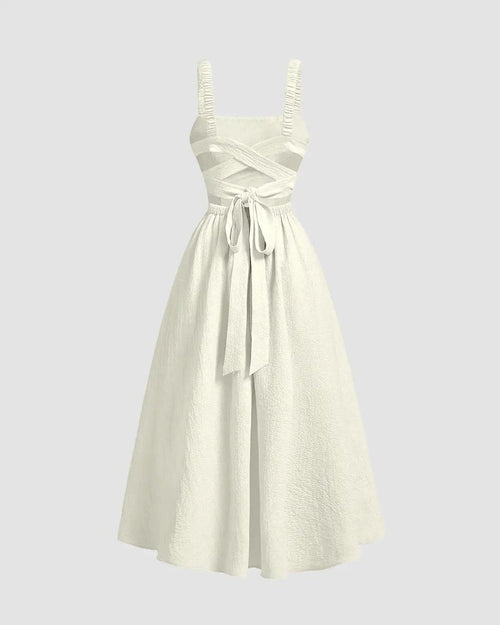 Off-white backless dress featuring a crisscross design and a bow at the waist, flared for a stylish silhouette.