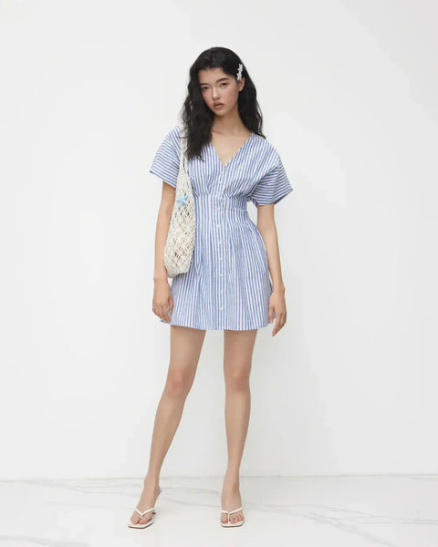 Front view of a woman in Blue and white striped button-down mini dress featuring a stylish V-neck design.