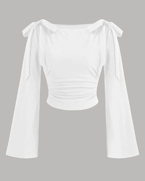 White boat neck top with long ruffled sleeves and a bow tie detail at the neckline.