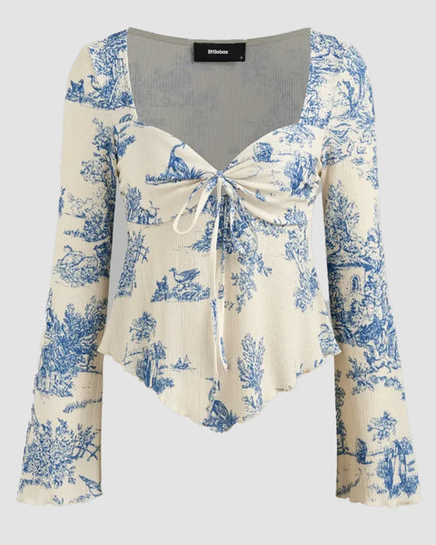 Front view of girls bell sleeve top with floral print, tie front detail and asymmetrical hem for a soft feminine look.
