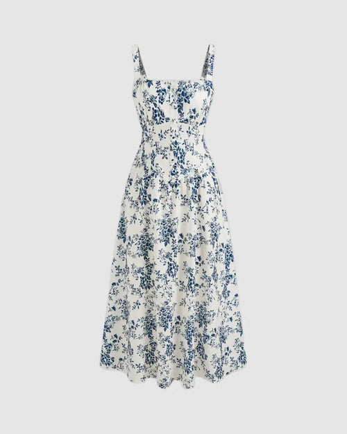 A square neck floral corset midi dress with lace up detailing, predominantly white with blue floral patterns.