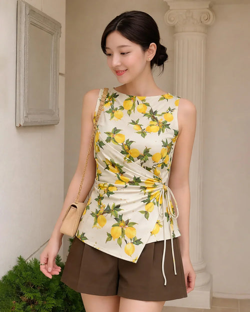 Women wearing Yellow floral sleeveless top with asymmetrical cut and ruched side tie, fitted waist tie-up design