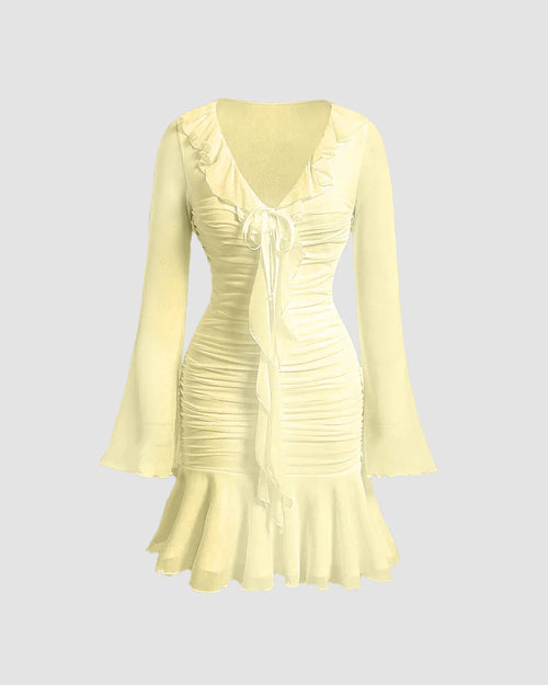 Front view of Pale yellow midi dress with ruffled V-neck, tie-up front and sheer long sleeves, fitted waist and flared hem.