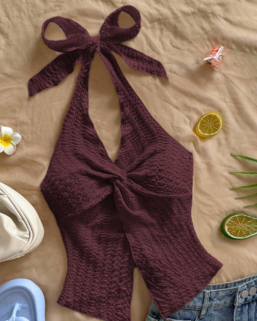 Front view of backless halter top in maroon with tie knot front, textured fabric and sleeveless fitted silhouette.