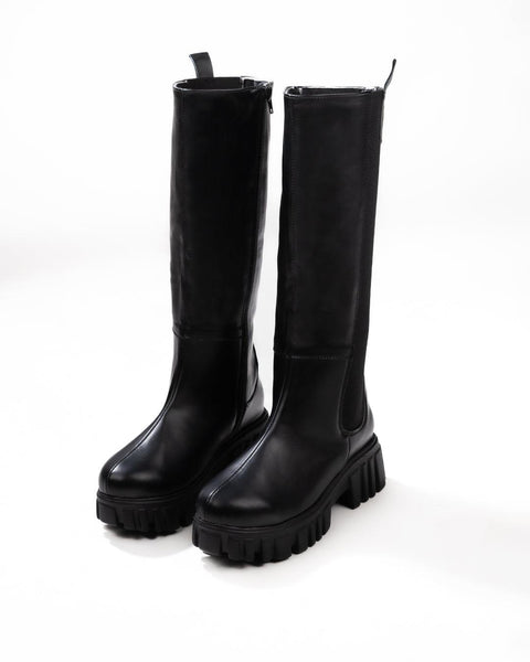 Front view of Black knee high boots with chunky lug sole, smooth leather finish, side stretch panels, and pull tab for easy wear.