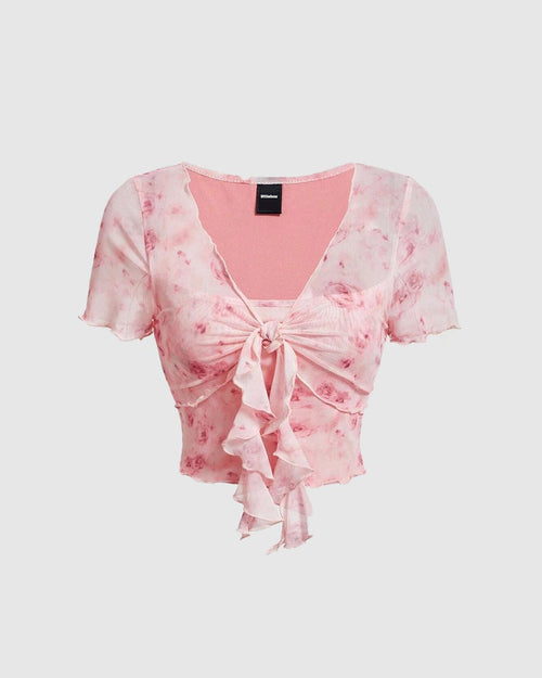 Front view of pink crop top featuring a ruffled neckline and tie front detail, designed with a printed lettuce trim