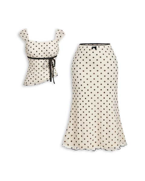 Front view of plus size co ords with polka dot print, asymmetrical top and mermaid tail skirt for a chic coordinated look.