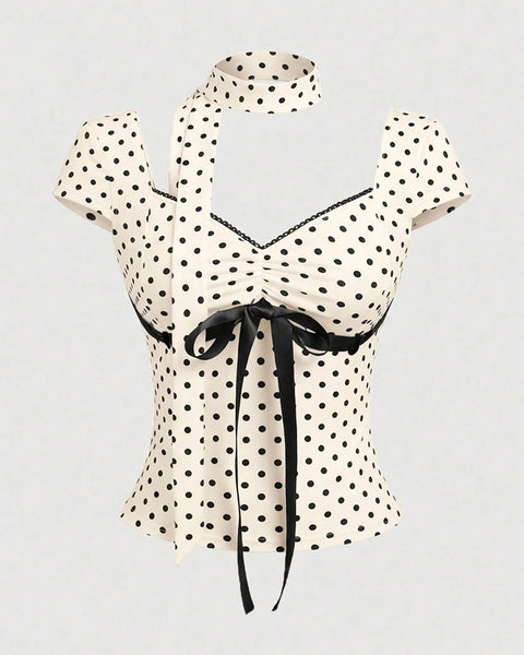 Front view of black and white polka dot top with sweetheart neckline, bow tie detail and fitted silhouette.