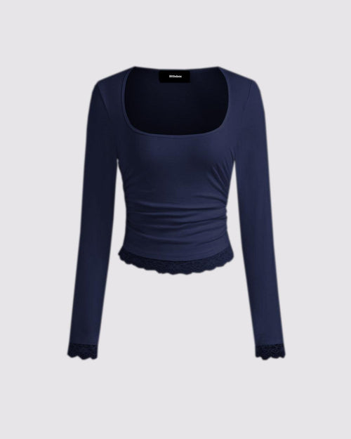 Navy blue long sleeve crop top with a square neck, made from soft knit fabric and featuring a lace bottom detail.