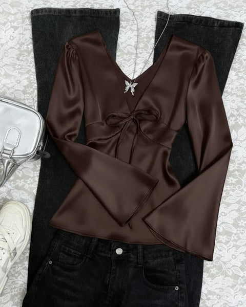 Front view of Coffee brown satin deep V-neck top with a front tie detail and long flare sleeves, offering a sleek, fitted and elegant silhouette