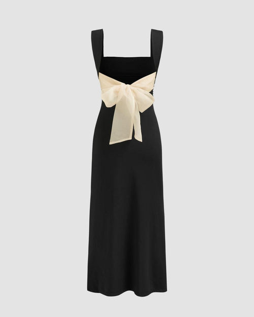 black maxi dress featuring a square neck and a white bow at the back