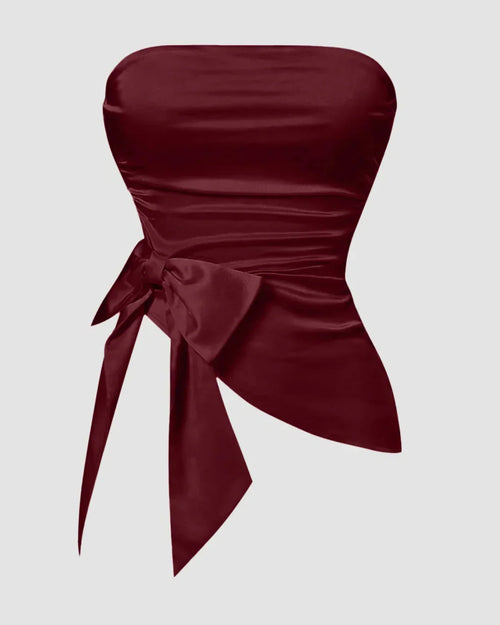 Front view of Red satin strapless sleeveless crop top with a slim fit design, ruched hem, and tie detail for a chic party look.