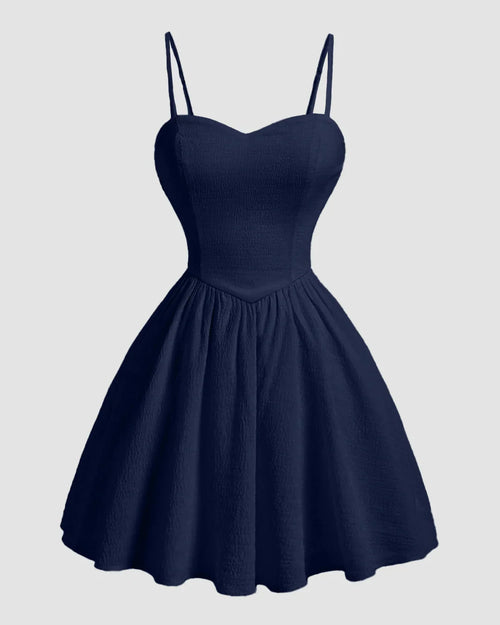 Front view of Navy blue mini dress with sweetheart neckline, spaghetti straps, fitted bodice, and flared skirt with back bow detail.