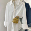 Front view of crisp white button-up shirt featuring a structured collar and long sleeves, offering a polished yet effortless silhouette.
