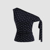 Front view of Black asymmetrical top with white polka dots, featuring ruched detailing and a side tie knot for a fitted, stylish silhouett