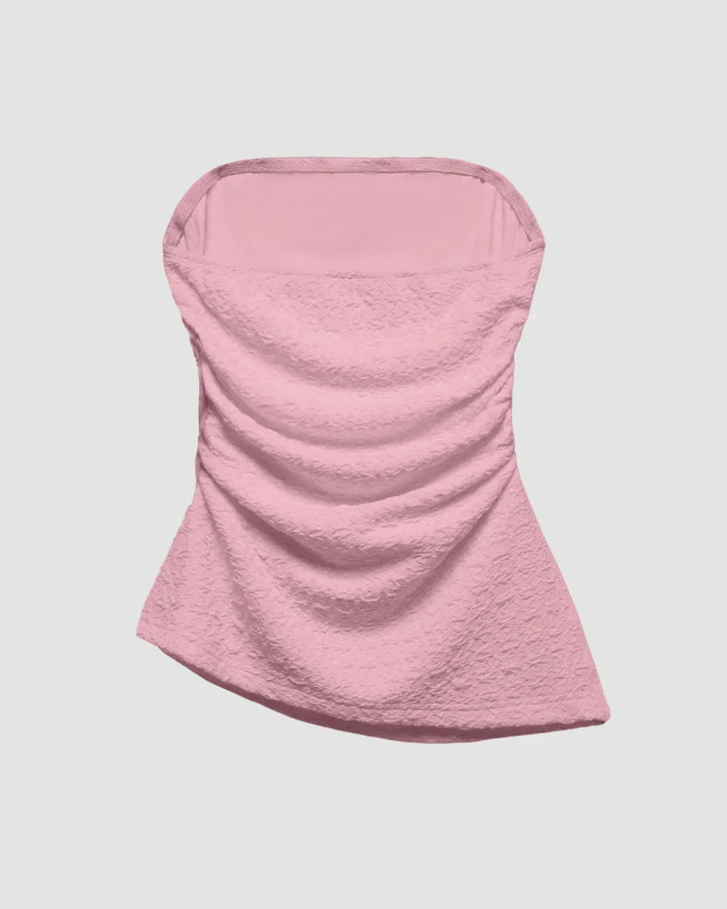 Ruched Baby pink tube top with an asymmetric hem, featuring a soft, textured design that flatters and adds a flirty touch on a light grey background 