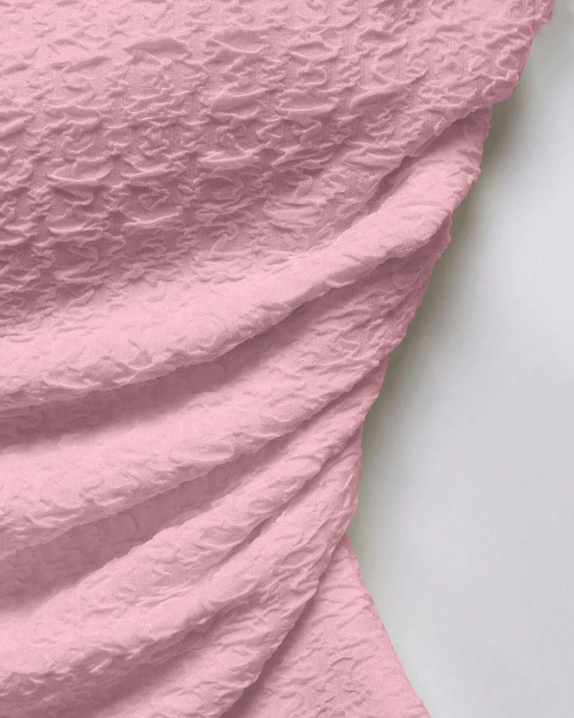 Close up of Ruched Baby pink tube top with an asymmetric hem, featuring a soft, textured design that flatters and adds a flirty touch