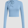 Powder blue cropped turtleneck top with a bow tie, designed for a slim fit