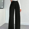 Front view of black wide leg trousers with high waist, pleated front and flowy silhouette for a tailored look.
