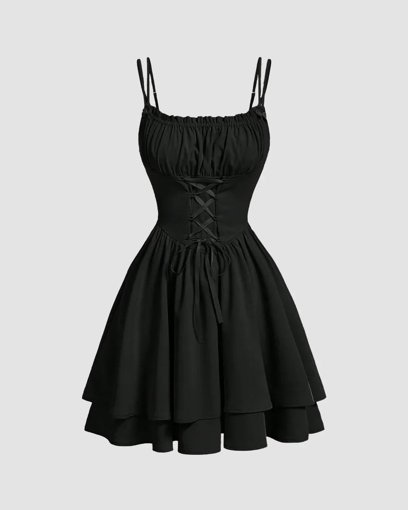 Black tiered mini dress with lace-up waist, flared layers, double spaghetti straps, and a flattering ruched neckline.