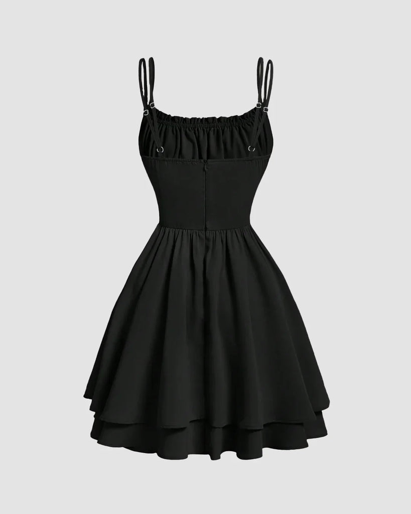 Back view of a Black tiered mini dress with lace-up waist, flared layers, double spaghetti straps, and a flattering ruched neckline.