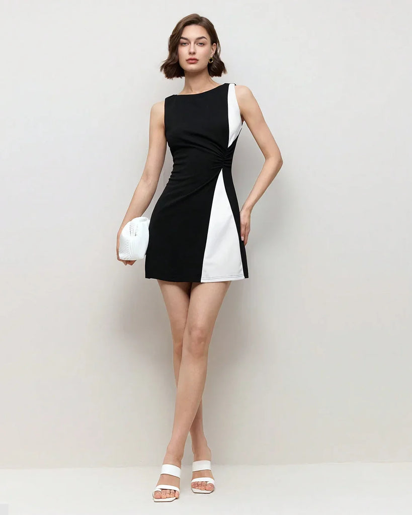 Model wearing a black and white color block bodycon mini dress, showcasing a stylish and modern design.
