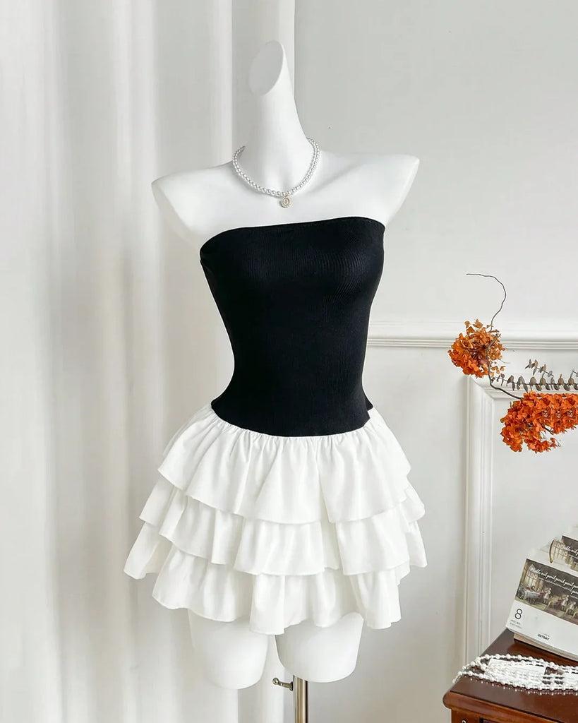 A strapless black and white tiered ruffle mini dress displayed on a mannequin.