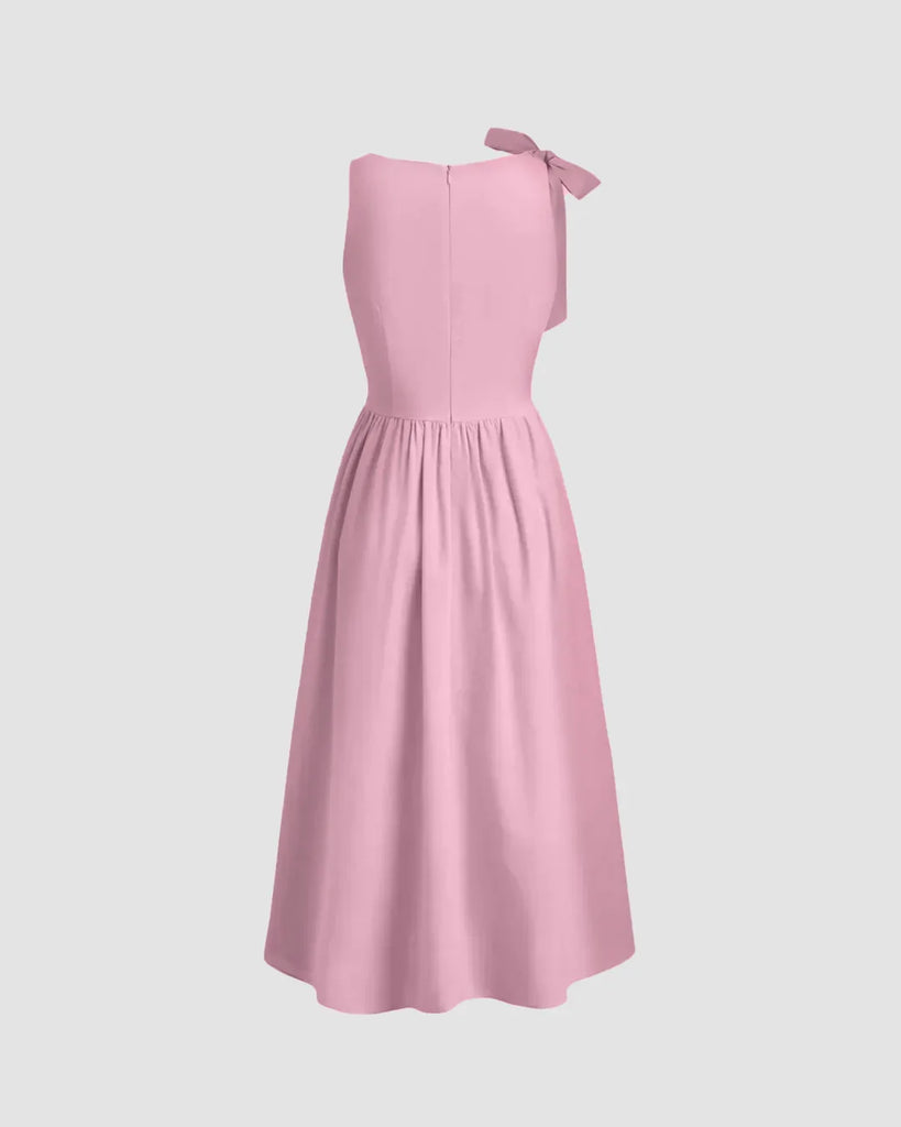 Back view of a Dark pink midi dress with a boat neck and bow detail at the shoulder, featuring a fit and flare silhouette.
