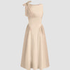 Fit and flare midi dress in light khaki with a clean boat neckline and dramatic bow tie shoulder, exuding soft elegance