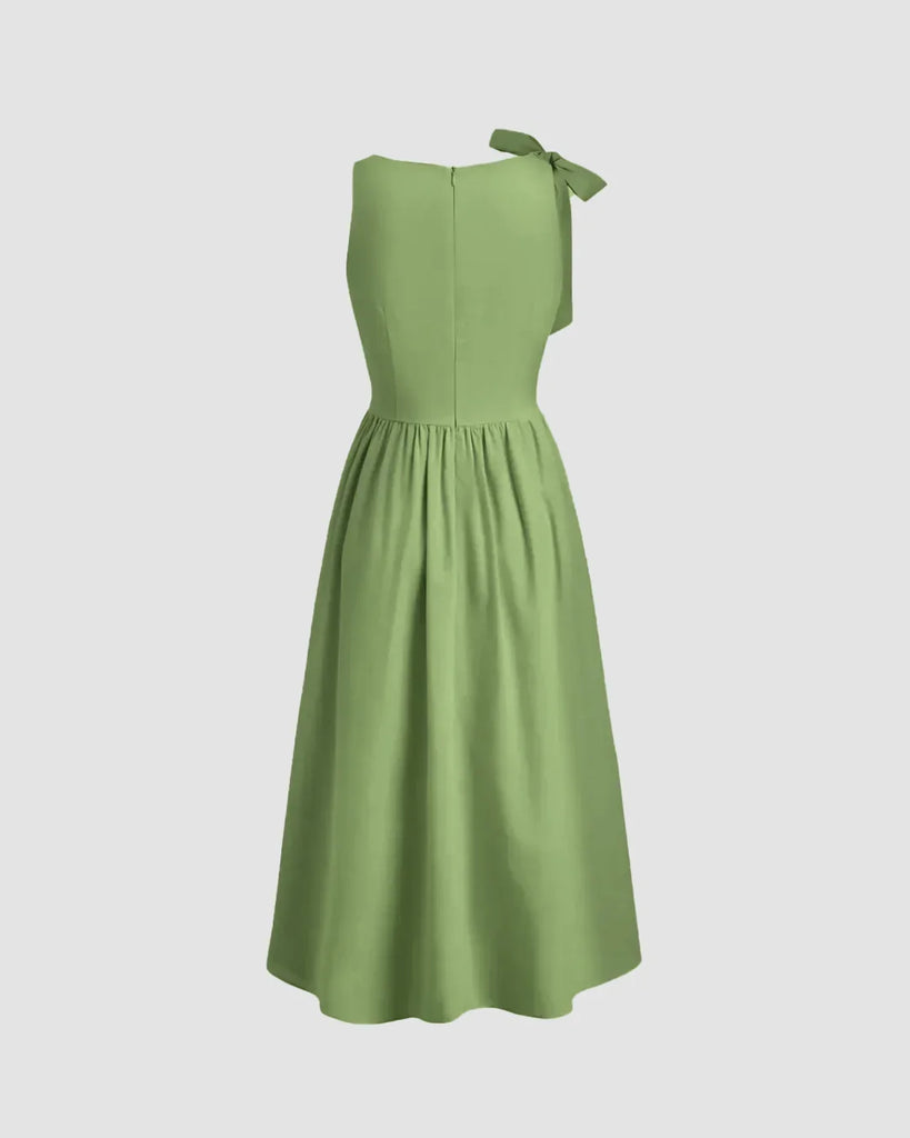 Light pista midi dress with a boat neck and bow detail at the shoulder, featuring a fit and flare silhouette.

