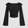 Black boat neck top with long ruffled sleeves and a decorative bow tie at the neckline