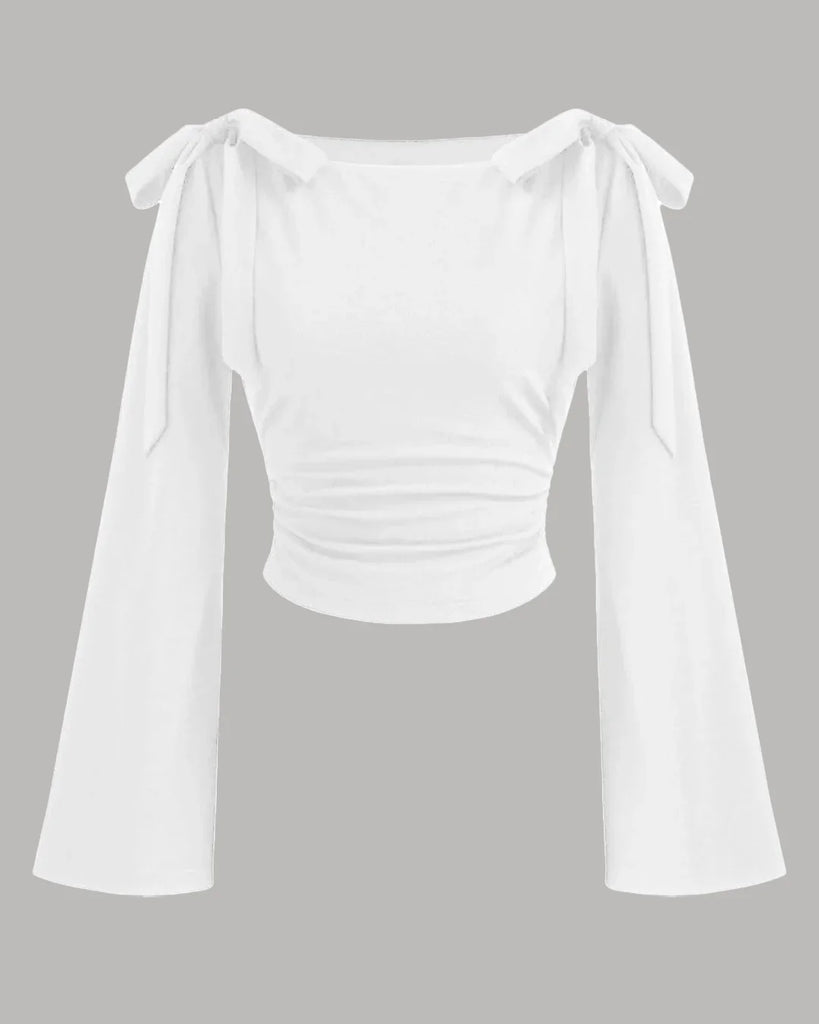 White boat neck top with long ruffled sleeves and a bow tie detail at the neckline.