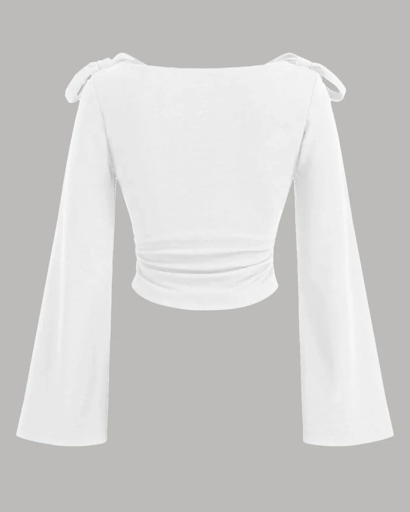 White boat neck top with long ruffled sleeves and a bow tie detail at the neckline.