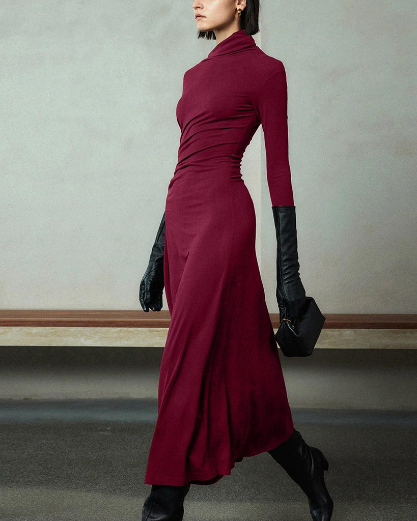 woman in a burgundy long-sleeve dress with an asymmetrical neck and black gloves side view