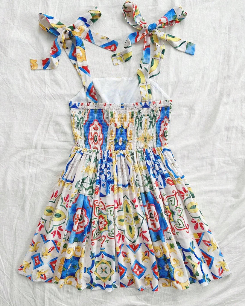 Back view of a bright mosaic print A-line mini dress that showcases vibrant colors.