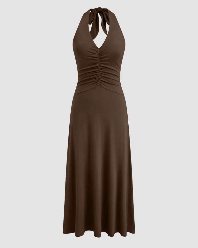 Brown halter neck midi dress with a backless design and ruched waist, showcasing a stylish and elegant silhouette.
