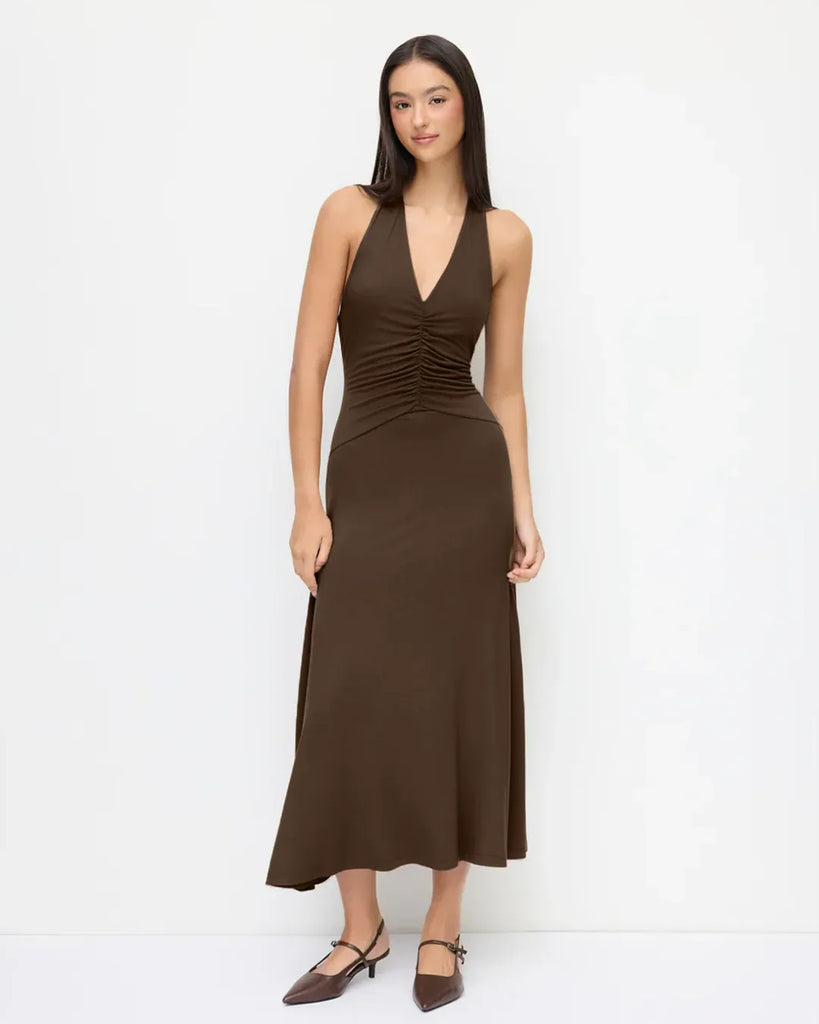 Brown halter neck midi dress with a backless design and ruched waist, showcasing a stylish and elegant silhouette.
