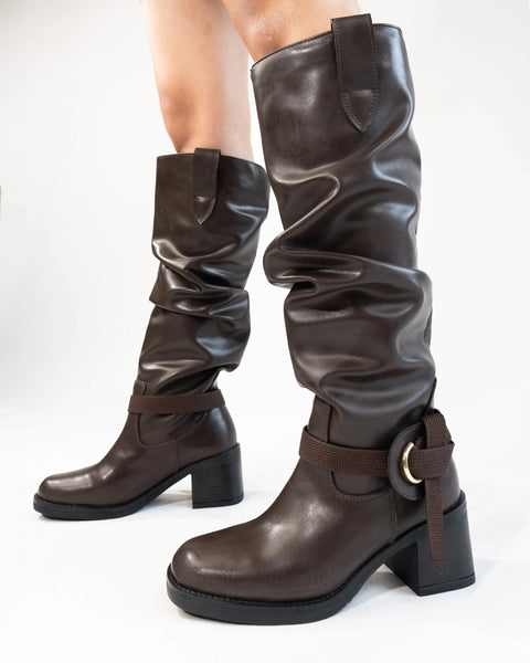 Women wearing Brown knee-high boots with buckle strap detail and sturdy block heel, sleek silhouette with structured finish