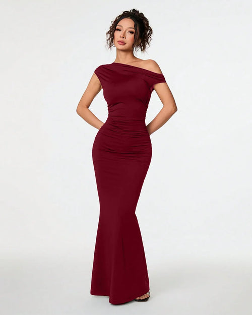 Front view of Burgundy asymmetrical neck bodycon maxi dress with fitted silhouette and flared hem, featuring an elegant sleek design