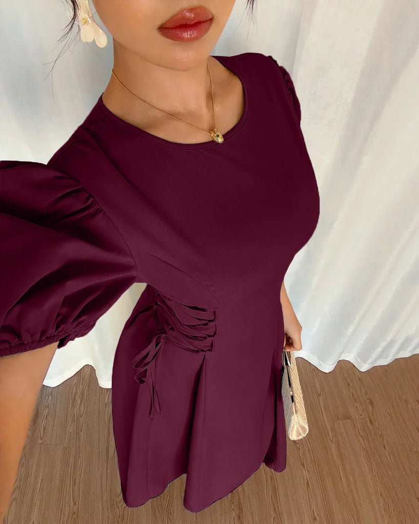 A woman models a burgundy puff sleeve A-line midi dress, showcasing its elegant design and rich color.