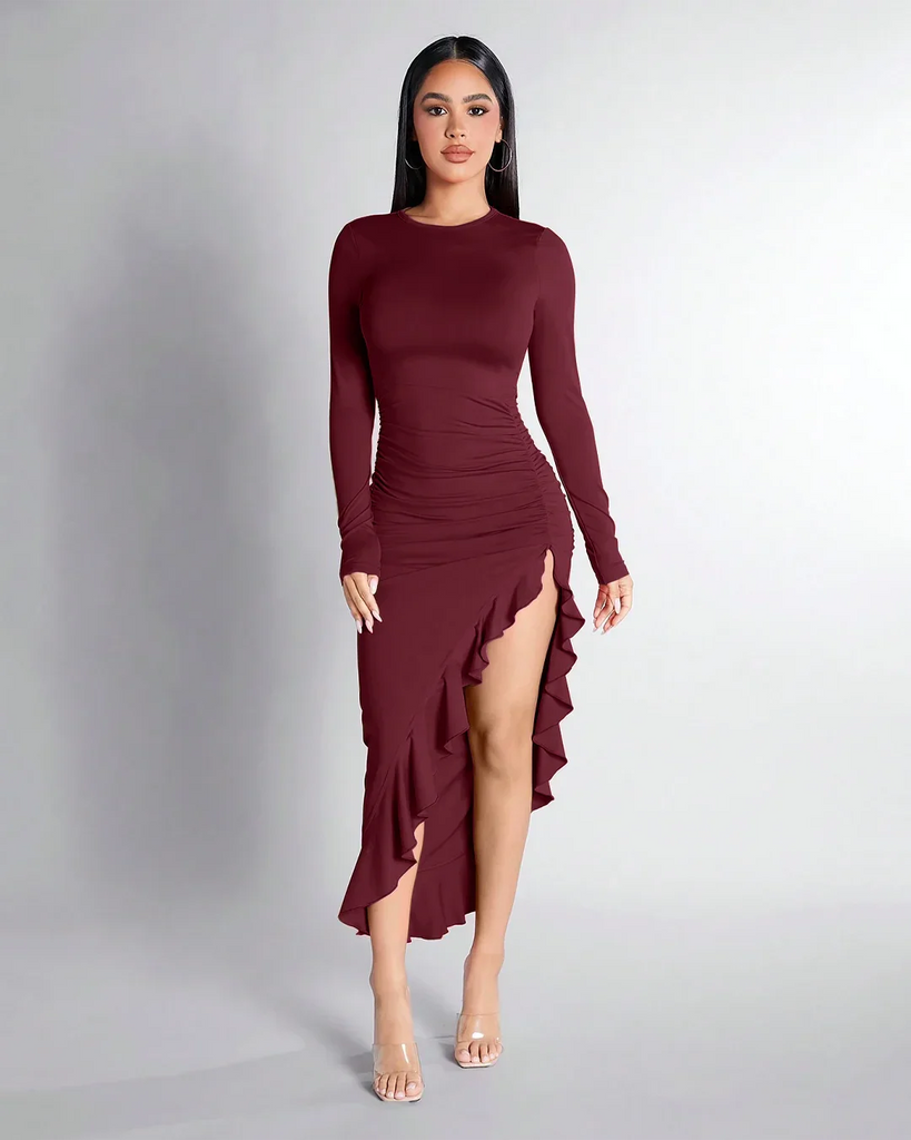 Long-sleeved burgundy dress featuring a high slit and ruffle hem, elegantly ruched for a flattering silhouette.