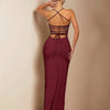 Woman's back view in a burgundy strapless bodycon maxi dress, highlighting the fitted design and flowing fabric.

