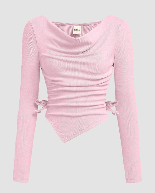 Front view of light pink top with ruched detailing, long sleeves and asymmetrical hem for a fitted look.