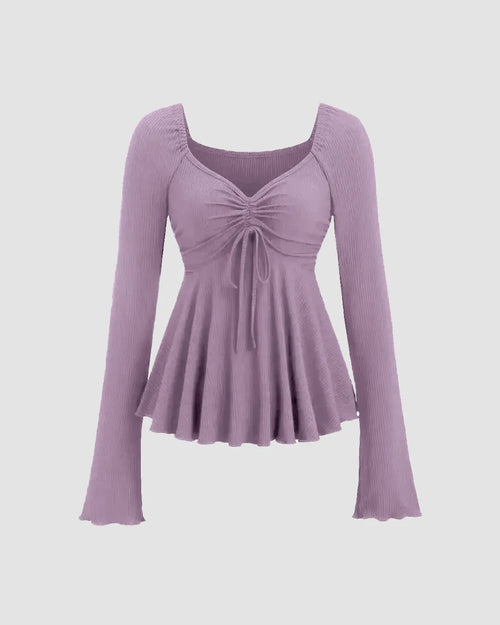 Front view of V-neck lilac flared long sleeve top with a ruched drawstring front and flared hemline for a soft, romantic silhouette.