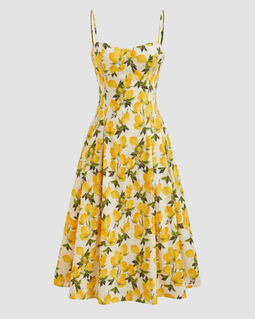 Front view of Yellow citrus floral fit and flare midi dress with spaghetti straps, lace-up front, and flowing skirt on neutral background.
