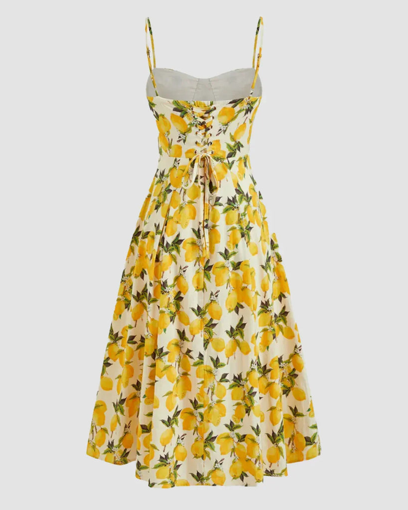 A strappy fit and flare midi dress featuring a vibrant lemon print, titled Citrus Bloom.
