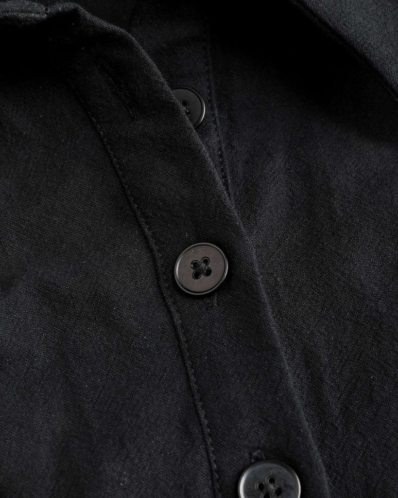 Close up of Cropped black full sleeve top with a collar, long sleeves, and ruched details, made from soft, lightweight fabric.