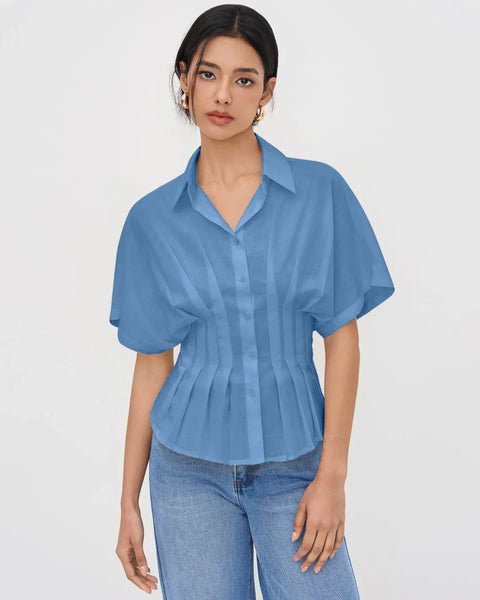 Women wearing light blue pleated shirt with a V-neck collar and short sleeves, featuring a cinched waist and structured fit for a polished look