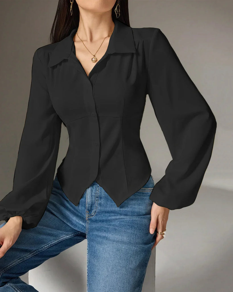 A woman in a black collared long sleeve shirt and jeans poses, showcasing a stylish and casual look.